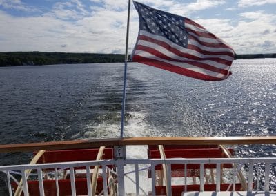 View of the paddle wheel boat from behind with the American Flag hoisted.