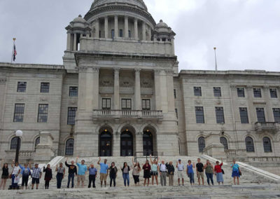 Group picture of tourist with the view of the Rhode Island State House in Providence, RI.