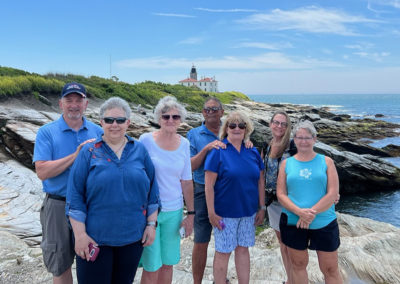 Group picture with the view of Beavertail Lighthouse in Jamestown, RI.
