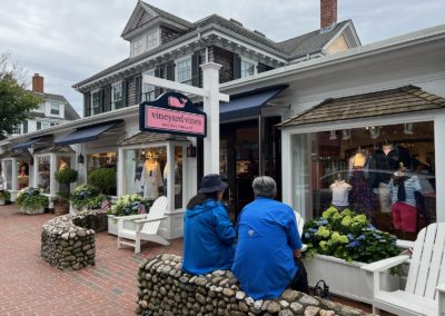 Two tourist sitting on the bench of Vineyard Vines Shop - a desitination included in A Day on Martha's Vineyard Tour.
