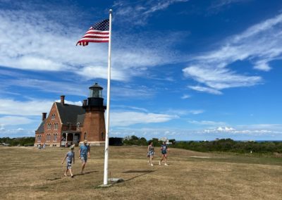 Picture of tourists walking away from The South East Lighthouse - an activity included in the Beautiful Block Island Tour.