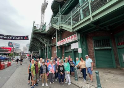 Group picture of tourists at the Fenway Park - a destination included in the Best of Boston Tour.