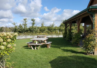 Two wooden outdoor tables and benches at the at The Sweet Berry Farm welcome the visitors to the farm.