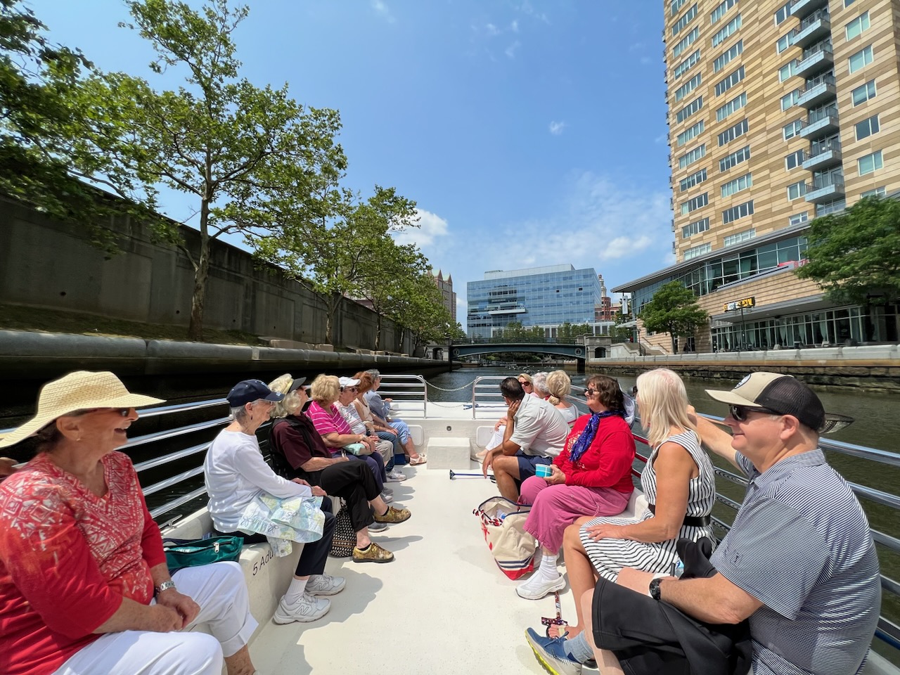 Group of elderly tourists on a cruise approaching the Providence Pedestrian Bridge.