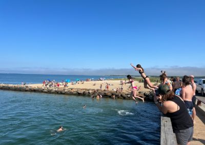 Tourists jumping off the Jaws Bridge in to the water - an activity included in A Day on Martha’s Vineyard Tour.