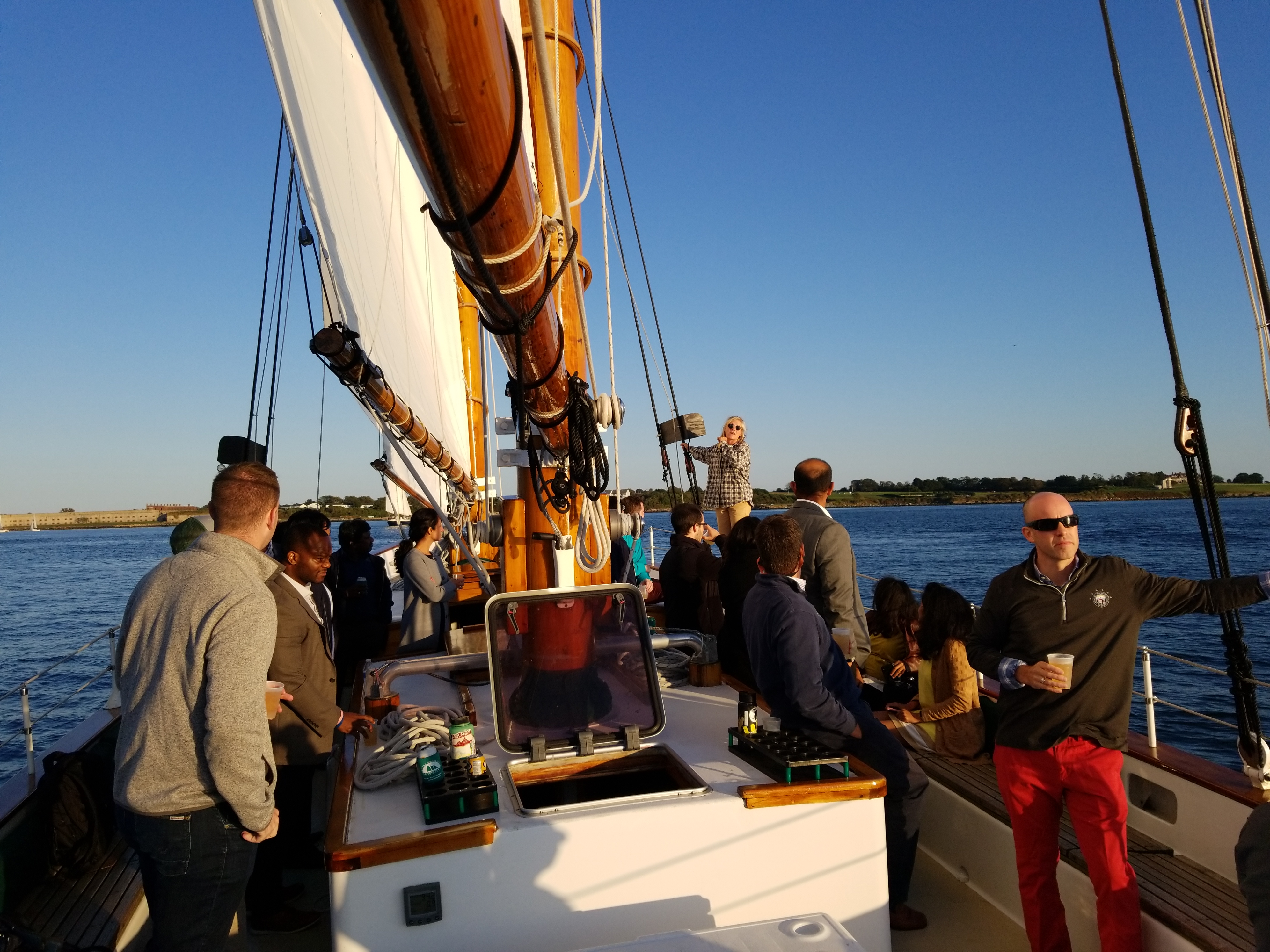 Tourist enjoying a sunset sail drinks - an experience included in The Coast Guard House & Sunset Sail Tour.