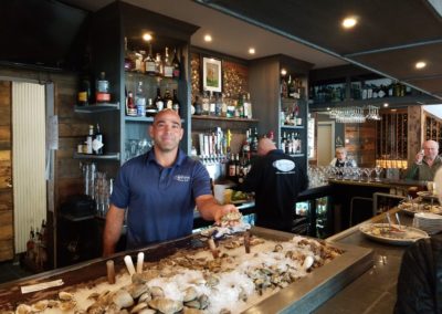 Oyster shucker working at Matunuck Oyster Bar - a destination included in the Scenic Rhode Island Tour.