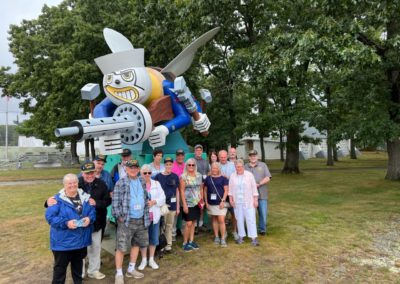 Group picture of tourists with The Fighting SEABEE Mascot of the US Naval Construction Battalion.